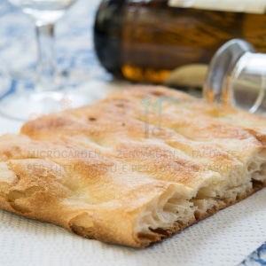 Pizza bianca croccante con olio d'oliva e rosmarino fresco.